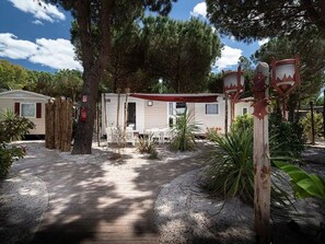 Un terrain de camping proposant des mobil-homes, une terrasse en bois et un kiosque.