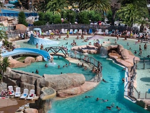 A large outdoor swimming pool with multiple water features, including slides and rock formations. - Mobile home with AC, pets welcome - 4 guests (Agde)
