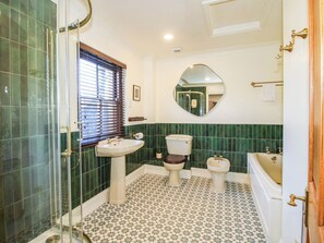 A bathroom with a glass shower enclosure, two toilets, a sink, and a bathtub. - Stone House Farm (Leominster)