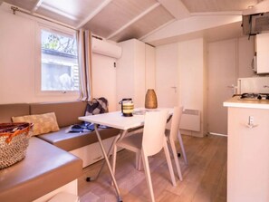 Une petite cuisine équipée avec une cuisinière, une petite table et un banc.