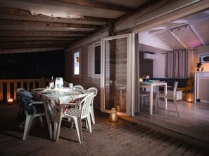 An outdoor dining area with a table set for two, a chair, and a lantern. - Air-conditioned mobile home - 6 guests (Agde)