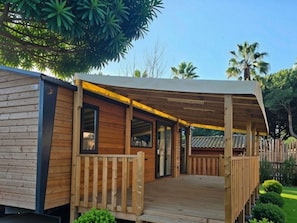 Eine Holzhütte mit überdachter Veranda und einem eingezäunten Garten.