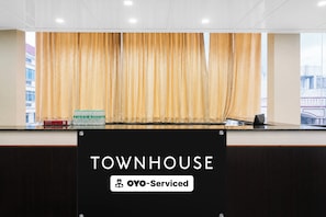 Una recepción con un cartel que dice 'TOWNHOUSE OYO-Serviced'.