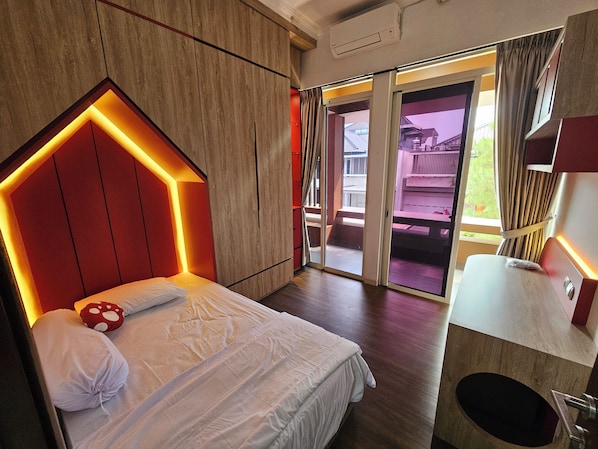 A hotel room with a bed, a wooden headboard, a bathroom, and a view of the outside.