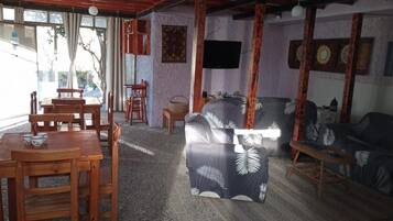 Una habitación con una mesa de comedor, sillas, un sofá y una televisión.