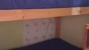 Un lit superposé avec un matelas bleu et une structure en bois.