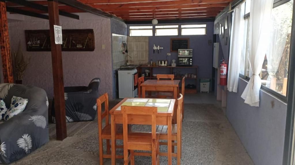 Un espacio habitable compacto con zona de comedor, kitchenette y sofá.