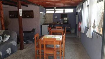 Un espace de vie compact comprenant un coin repas, une kitchenette et un canapé.