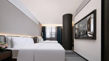 Quarto de hotel com uma cama grande, mesa de cabeceira, escrivaninha e uma janela ampla com cortinas.