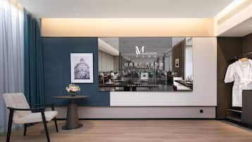 A modern hotel lobby with a seating area, a mirror reflecting the interior, and a QR code for information.