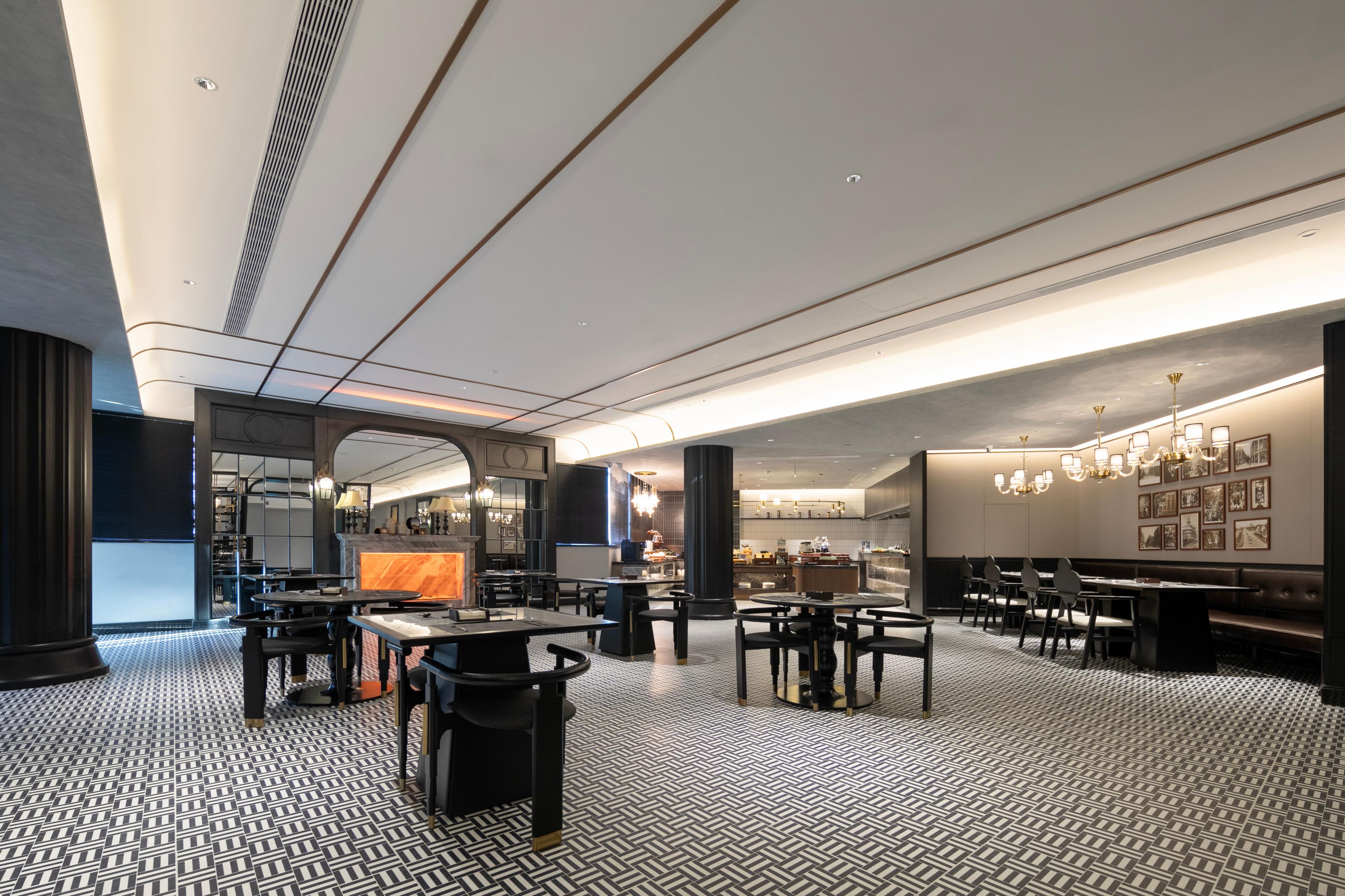 Een modern restaurantinterieur met een patroon vloer, zwart-wit meubels en een bar.