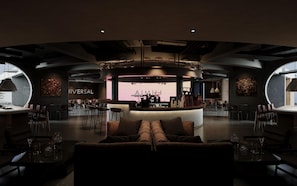 Interior moderno com área de bar central, espaços de estar e o letreiro 'AIMITHI' visível.