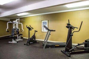 Ein Fitnessstudio mit Cardiogeräten, Krafttrainingsgeräten und Laufband.