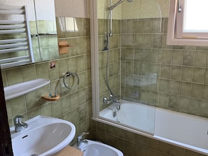 Ein Badezimmer mit zwei Waschbecken, einer Dusche und einem Spiegel.