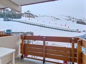Een piste bedekt met sneeuw, met een houten hek op de voorgrond.