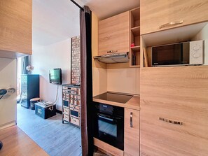 Una cucina moderna con elettrodomestici integrati, mobili in legno e una parete decorata con mattoni.