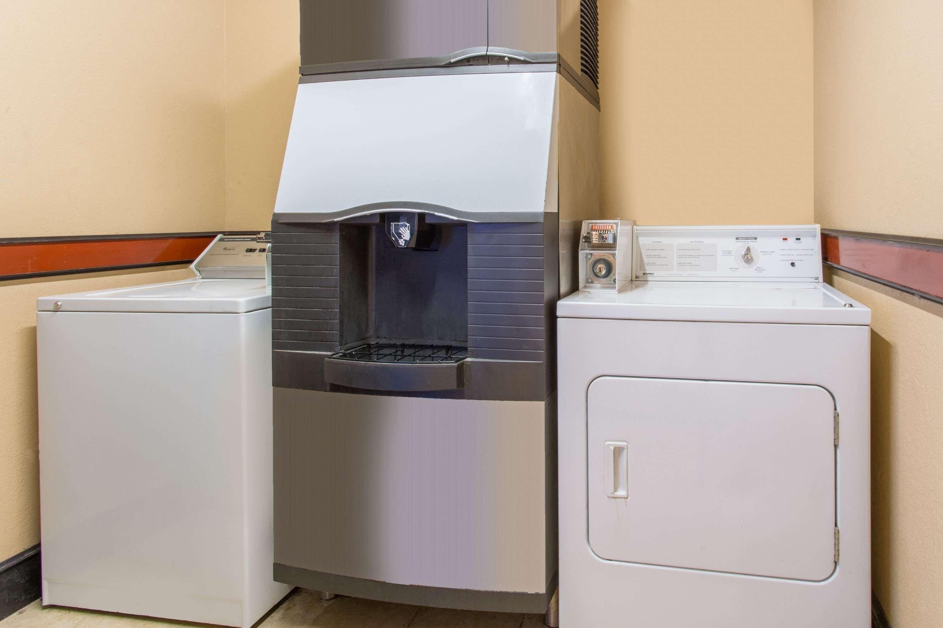 A laundry facility with a water dispenser and two washing machines.