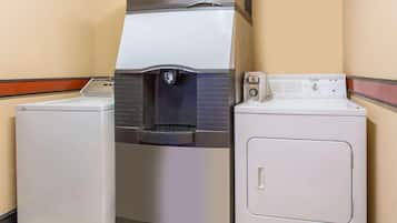 A laundry facility with a water dispenser and two washing machines.