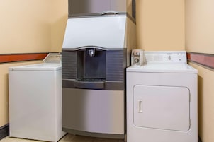 Una sala de lavandería con dispensador de agua y dos lavadoras.