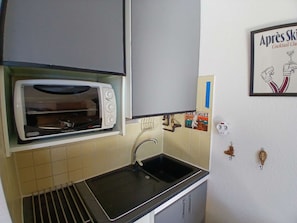 A kitchen with a built-in toaster oven, a sink, and a wall-mounted picture. - 2-room apartment - 5 guests, south balcony, L'Alpe d'Huez (Huez)