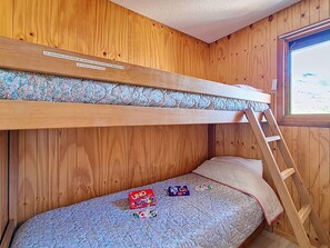 A bunk bed with a ladder, a window, and a bed with UNO and UNO Deluxe game boxes. - Comfortable apartment - 4 guests. At the slopes (Les Menuires)