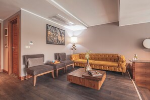 Un saló modern amb un sofà, dues butaques, una taula de centre i una làmpada.