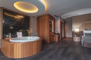 Un baño moderno con una bañera independiente, paneles de madera y encimera de mármol.