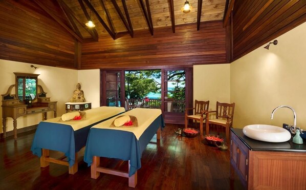 A room with two beds, a wooden ceiling, a window with a view, a sink, and a cabinet. - JA Enchanted Island Resort (Round Island)