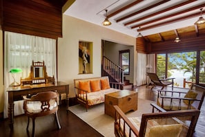 A spacious living area with a sofa, chairs, a desk, and a staircase leading to an upper level. - JA Enchanted Island Resort (Round Island)