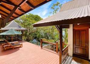 A wooden deck with a pool, lounge chairs, and a covered seating area. - JA Enchanted Island Resort (Round Island)