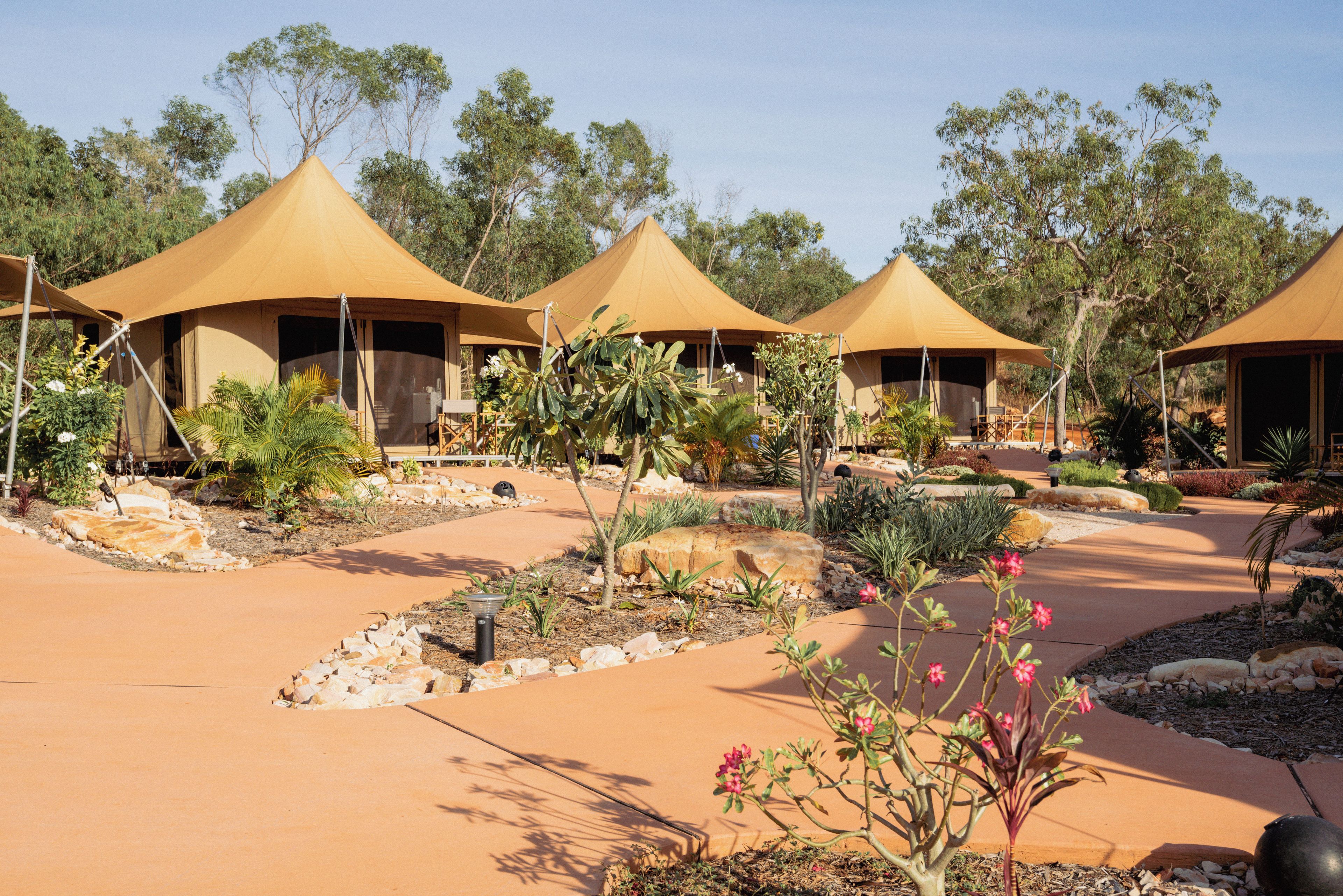 A series of tents with a paved walkway and landscaped garden.