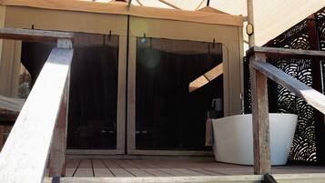 A wooden staircase leading to a covered outdoor area with a canopy.