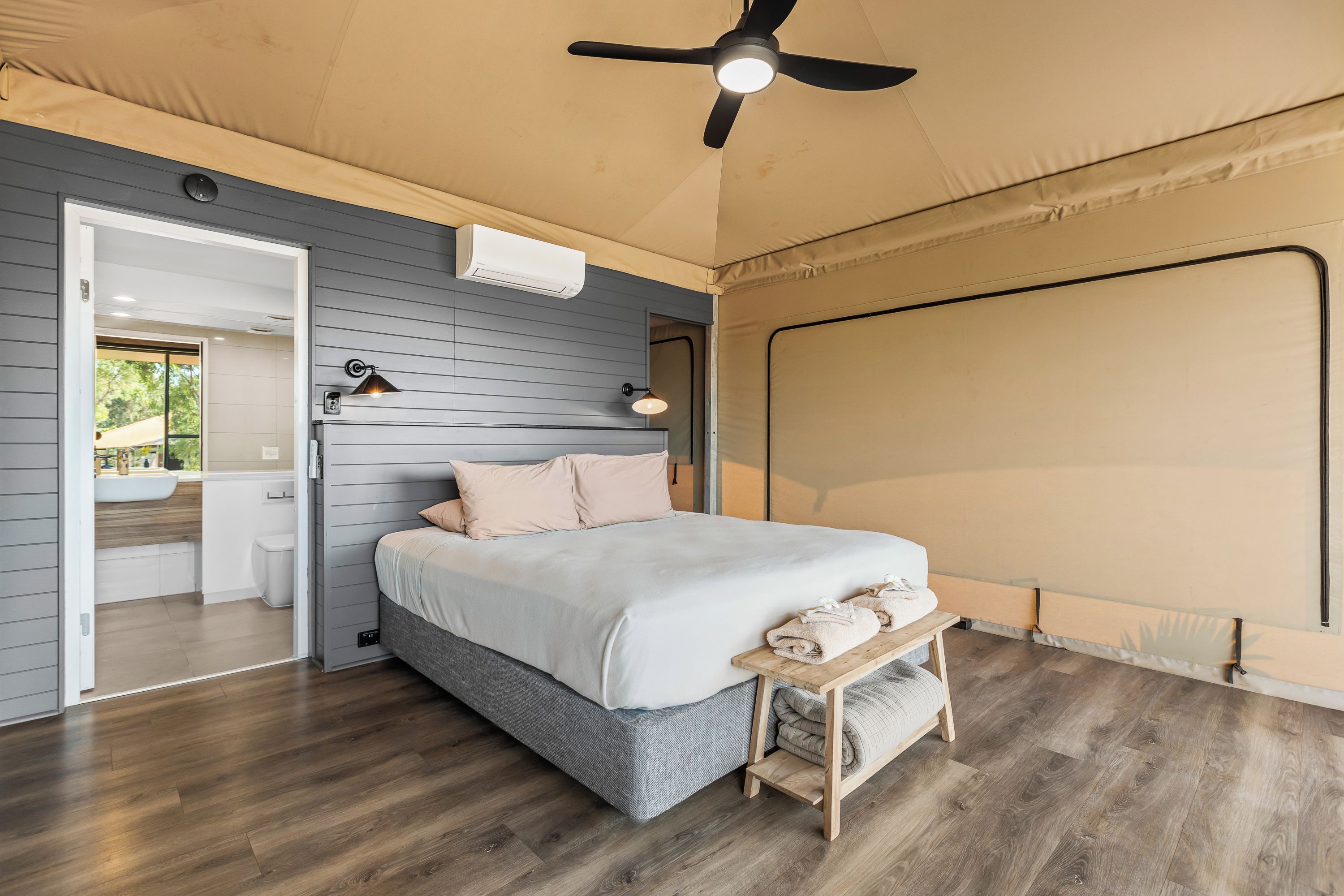 Una camera da letto con un letto, un comodino e una ventola a soffitto.