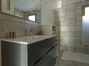A modern bathroom with a large mirror, a sink, and a shower area. - Family house, parking, pets - 6 guests (Valloire)