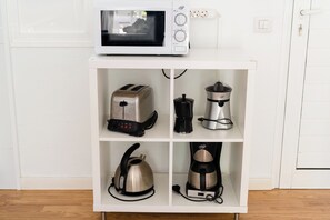 A white kitchen cabinet with four compartments containing a toaster, a coffee maker, a kettle, and a blender. - Villas New Lanzasuites - Only Adult (Yaiza)