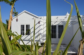 A white building with a flat roof and a small porch area.