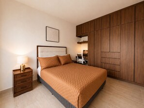Un dormitorio con cama, mesita de noche, lámpara y armario.