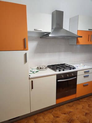 A kitchen with a gas stove, oven, and a range hood. - MAISON PLATONE JOLIE (Alessandria)