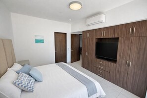 Ein Schlafzimmer mit einem Bett, einem Fernseher und Holzschränken.