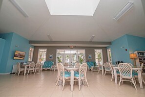 A spacious dining area with high ceilings and natural light from large windows. - Seaside at Anastasia B104 Condo (St. Augustine)