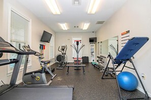 Ein Fitnessraum mit Laufbändern, Ergometer, einer Bank und einem Ball.
