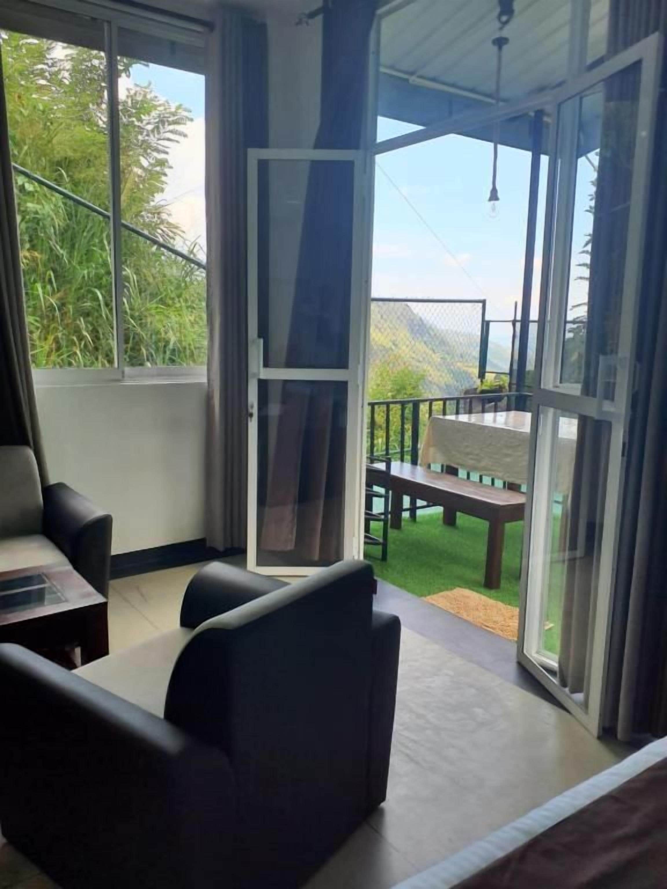 A room with a sliding glass door leading to an outdoor area with a bench and a table.