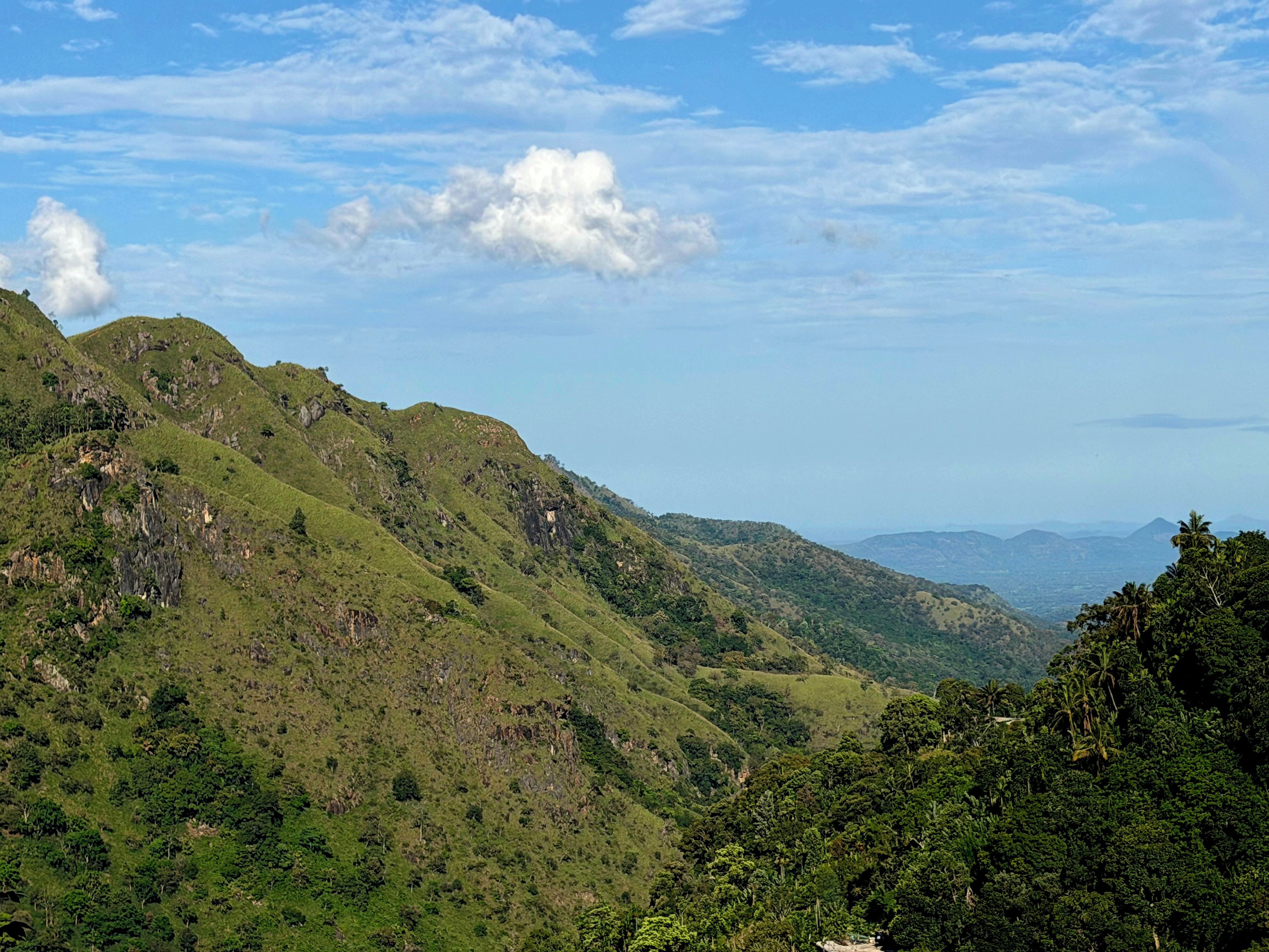 A mountainous landscape with lush greenery and a clear sky.