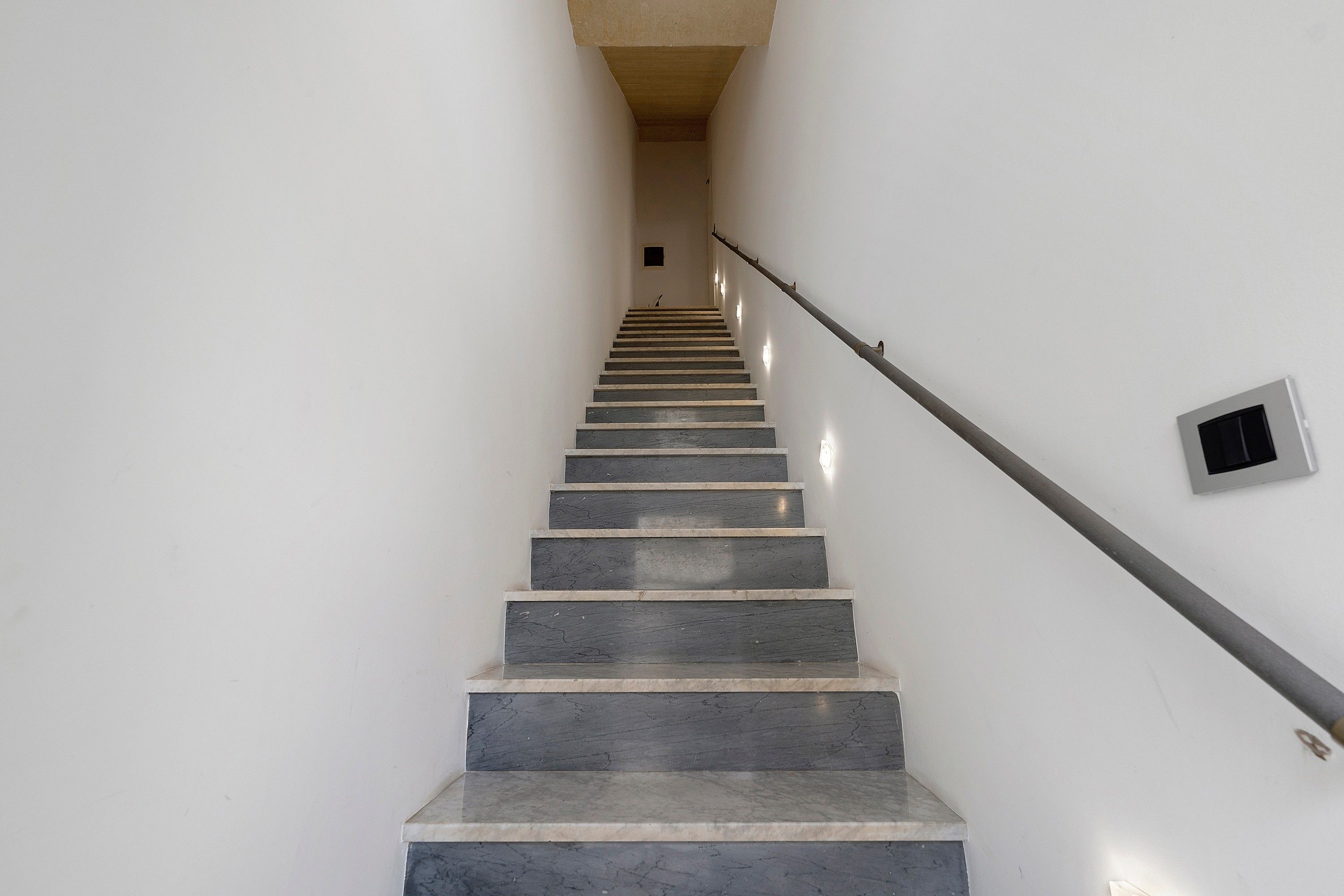 Un escalier avec une rampe menant à un palier.