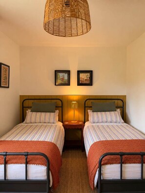 A room with two beds, a woven light fixture, and two framed pictures on the wall. - Groom's Cottage, Jedburgh (Jedburgh)