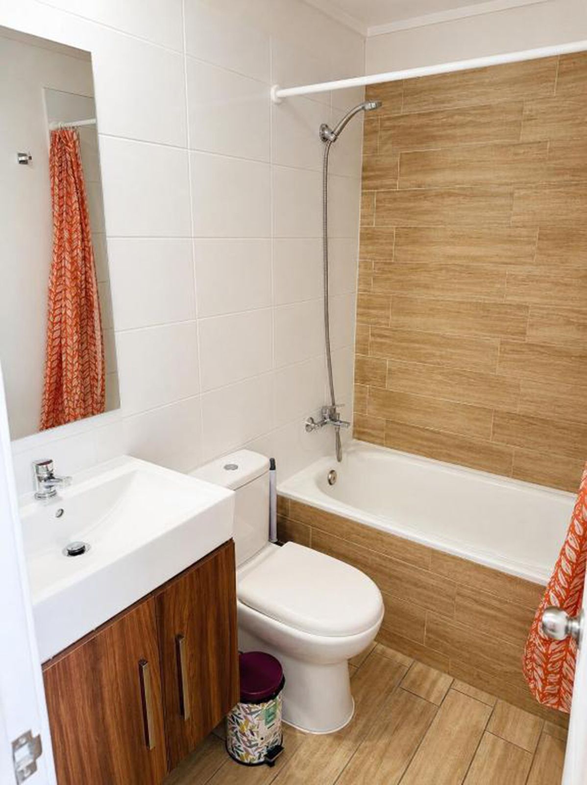 Casa de banho com lavatório branco, sanita e banheira.
