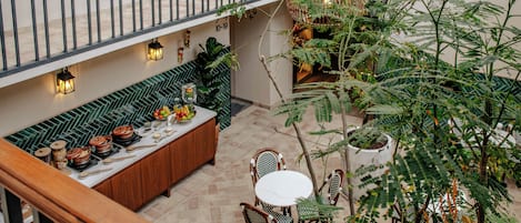 Uma área de refeições com um longo banco de madeira, uma mesa redonda e cadeiras.