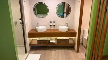 Un baño con dos lavamanos, dos espejos y un mueble de tocador de madera.