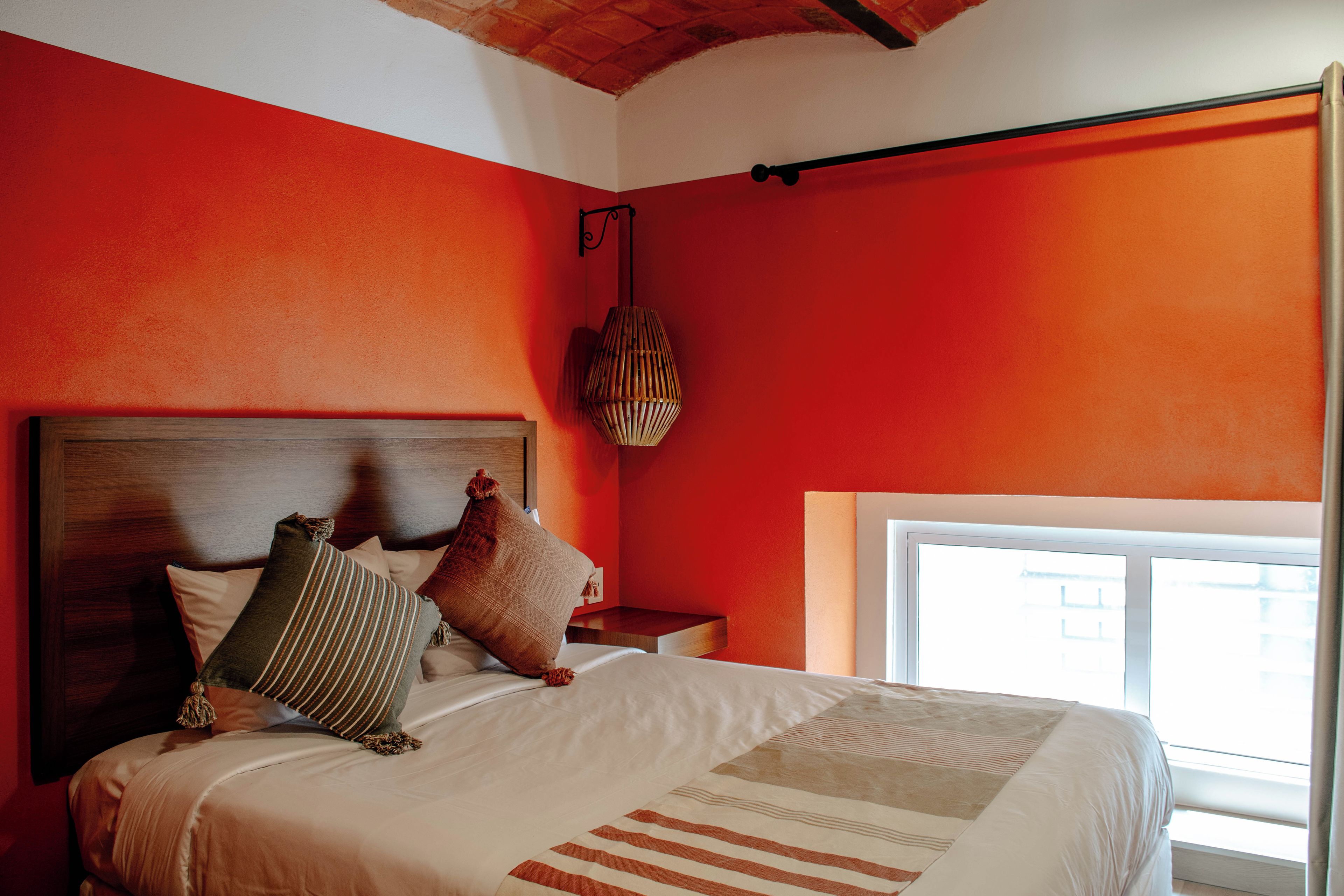 Un dormitorio con una cama grande, cabecera de madera y una ventana con cortinas.