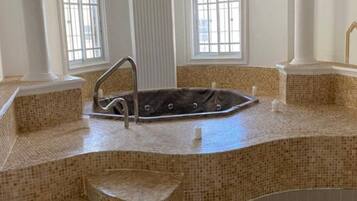 A spa area with a hot tub, steps, and large windows.